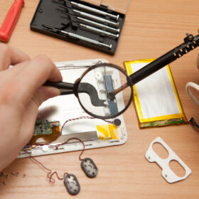 Master solder wires exploded tablet computer. He looks through a